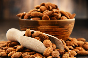 Bowl with shelled almonds on wooden table