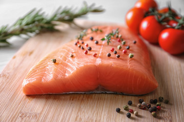 Peppered salmon fillet on wooden cutting board