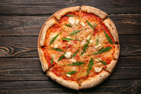 Delicious pizza on wooden table, top view