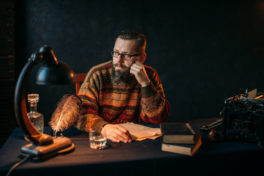 Bearded writer in glasses sitting at the table