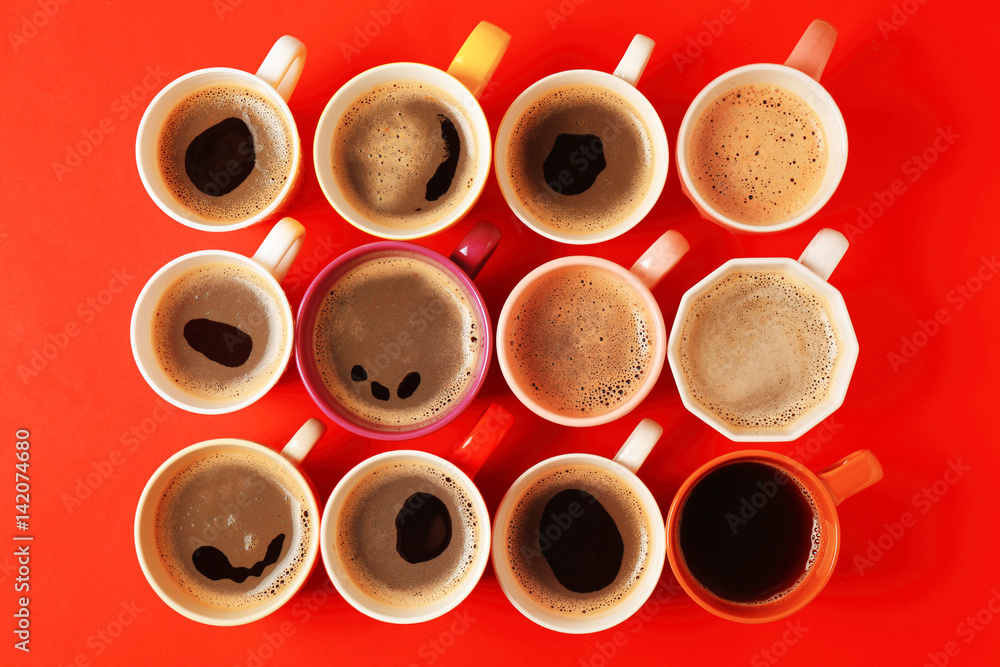 Wall mural Cups of coffee on red background