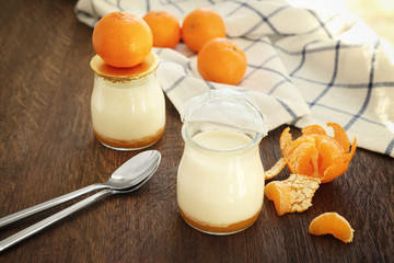 Fruit yogurt and tangerines on wooden table
