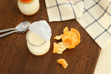 Fruit yogurt and tangerines on wooden table