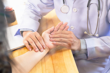 Obraz premium Doctor hands feeling pulse on female wrist