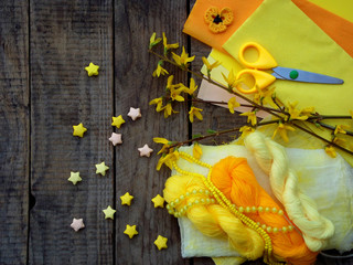 Composition of yellow accessories for hobby on grey wooden background. Knitting, needlework, sewing, painting, origami. Small business. Income from hobby.