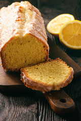 Homemade lemon bread on wooden background.