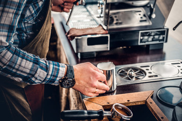 A man preparing cappuccino in a coffee machine.