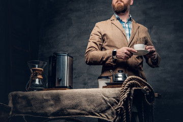 A man near a table with coffee machine over grey background.