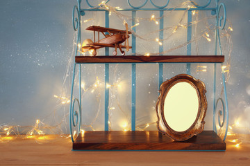 Vintage shelf with old wooden plane toy and blank photo frame