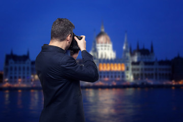 Photographer takes pictures of palace on the river