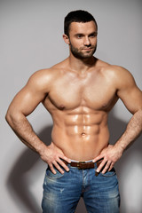Fototapeta premium Handsome Smiling Young Man With Sexy Fit Muscular Body Indoors