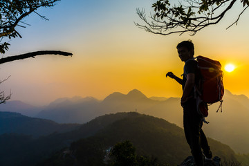 Hiking man stand on hill enjoying sunset