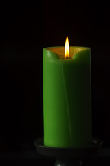 Single Green Candle on black background