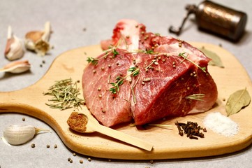 raw meat on a wooden cutting board with spices