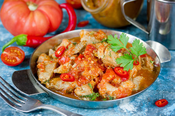 Canned stewed pork meat in pepper tomato sauce