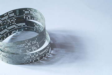 Strips of old punched tape on a white surface