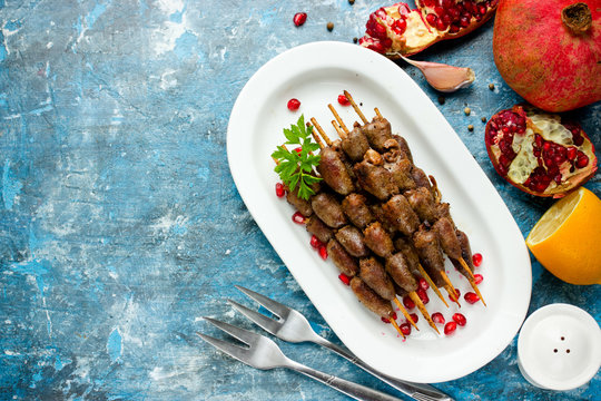 Grilled chicken hearts on skewers with pomegranate, lemon and garlic