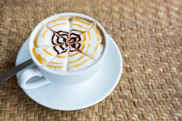 Cappuccino cup on weaving a mat