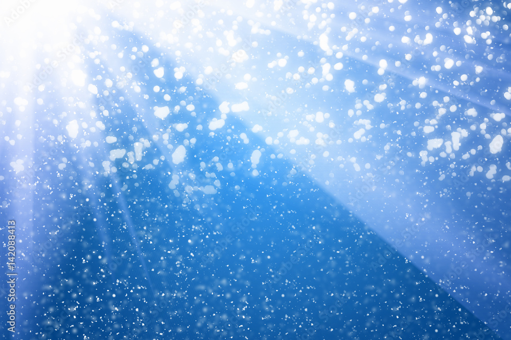 Poster abstract bokeh glitter lights and rays on blue background. round defocused circle particles. christm