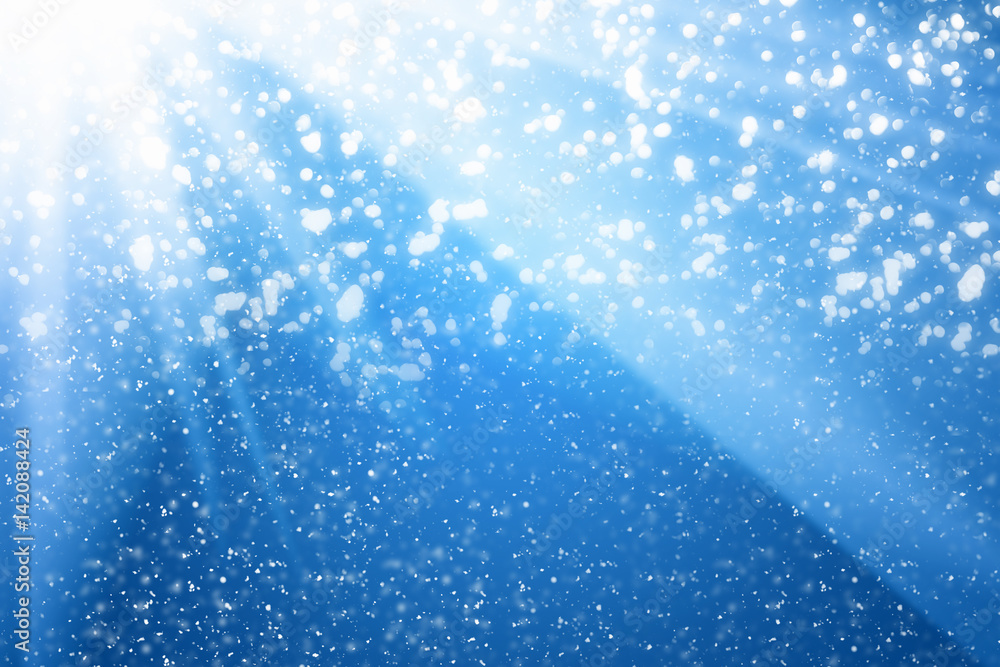 Poster abstract bokeh glitter lights and rays on blue background. round defocused circle particles. christm