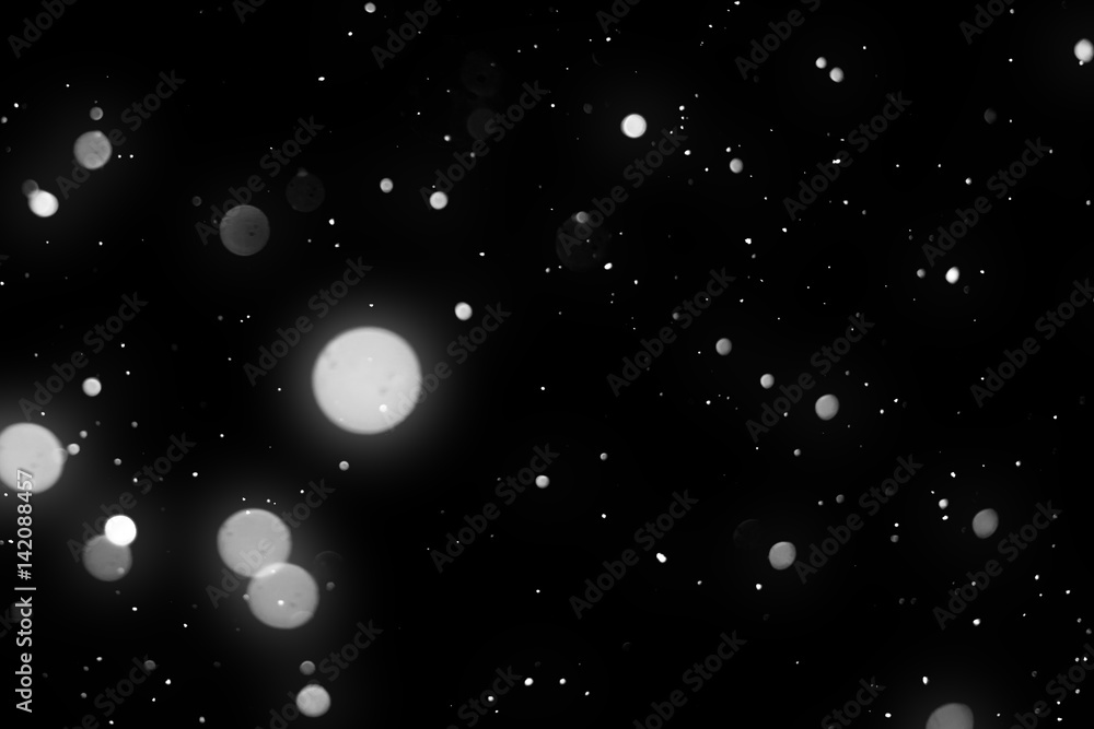 Poster snowfall isolated on black background. round bokeh or snowflakes particles . design element
