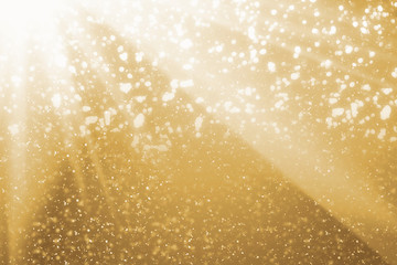 Golden rays and sparkles or glitter lights. Merry Christmas festive background.defocused circle bokeh or particles