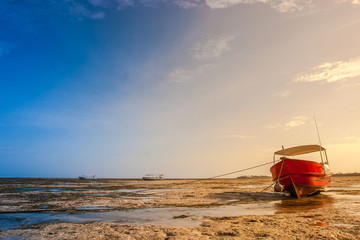 Obraz premium The boat is on the rocks. Beautiful low tide on the ocean.