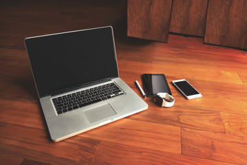 Office stuff with notepad, laptop, smartphone, pen and watch on the brown wooden desk. Top view with copy space.