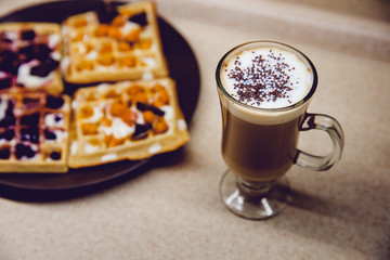 Breakfast in the kitchen. Coffee and Wafers with chocolate, cloudberries, blueberries and ice cream.