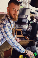 Bearded coffee seller on his workplace in a small street cafe.
