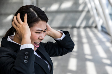 young businesswoman holding her head © metamorworks