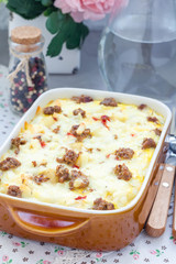 Egg casserole with potatoes, sausage and pepper, in baking dish, vertical