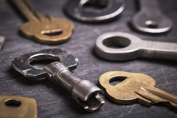 Old keys on a dark wooden background.