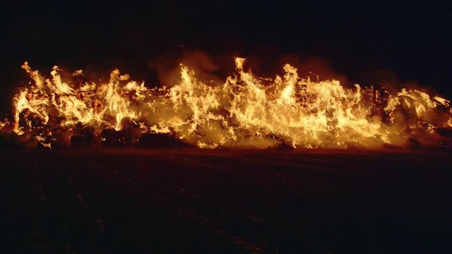 Fire storm, horrific fire destroys gigantic hay bales construction, Red Epic slow motion clip