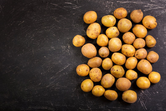 fresh potatoes on dark table
