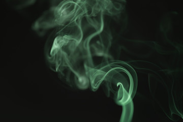 mystery wavy green smoke rising over black background