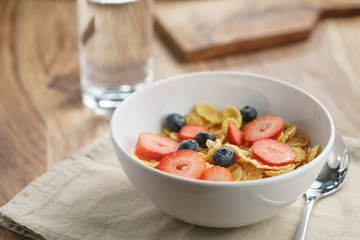 dry corn flakes with berries in bowl on table