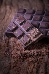 Chocolate bar pieces. large bar of chocolate on wooden background. Slices of chocolate Sweet food photo concept
