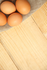 Fresh chicken brown eggs on linen napkin at rustic wood table.