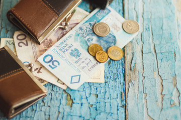 Polish zloty with little wallets on the old wooden background