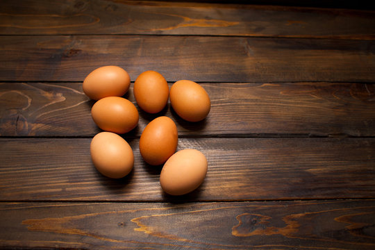 Closed, fresh chicken eggs on a natural wooden background