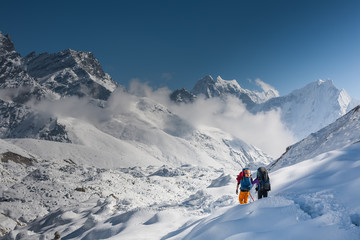Naklejka na ściany i meble Trekkers crossing Gokyo glacier in Khumbu valley on a way to Everest Base camp