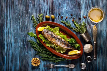 Baked mackerel with lemon on a rustic wooden background - obrazy, fototapety, plakaty