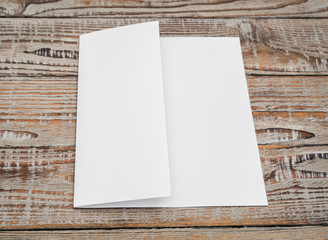 Trifold white template paper on wood texture .