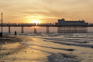 Photographer Shooting the Sun as it Rises Behind Worthing Pier