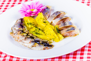 Salted herring and mackerel with boiled potatoes on a white plate