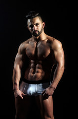 Fototapeta na wymiar handsome muscular macho man with sexy athlete body in pants