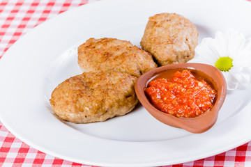 Beef cutlets with tomato sauce on white plate