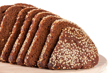 slices of black bread with sesame seeds on a cutting board isolated on white background