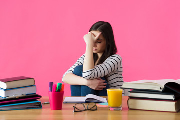 Frustrated female student. Young student with desperate expression sitting at her desk.
